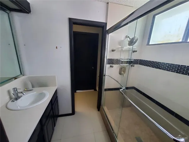 a bathroom with a sink a mirror and a shower