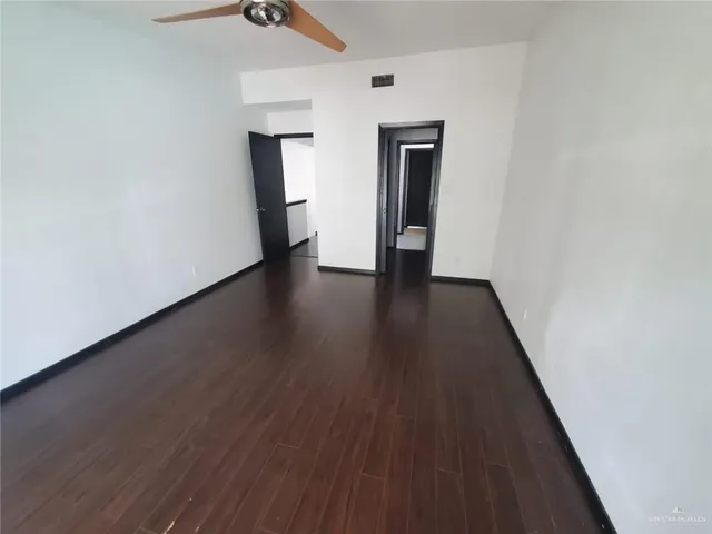 a view of a hallway with wooden floor and closet