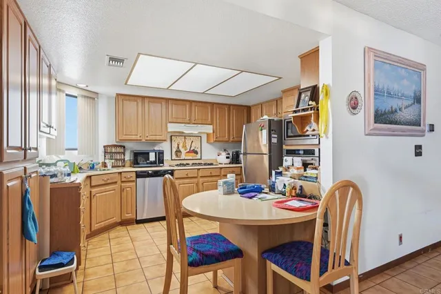 a kitchen with stainless steel appliances kitchen island granite countertop a dining table and chairs