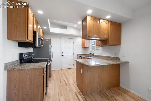 a kitchen with stainless steel appliances granite countertop a sink stove and refrigerator