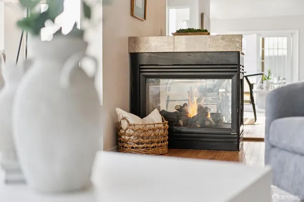a living room with stainless steel appliances kitchen island granite countertop furniture and a fireplace