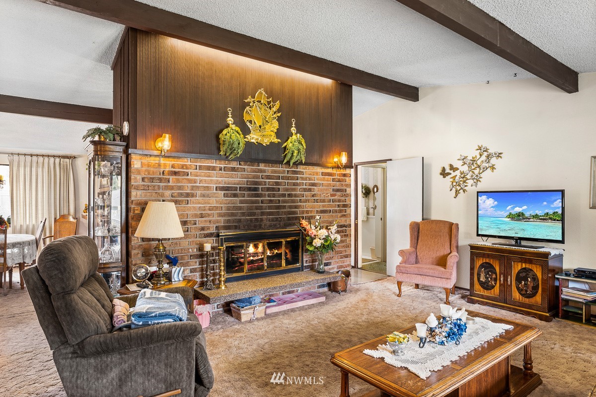15053 Southeast 113th Street Renton, WA 98059 - Photo 6 of 31 a living room with furniture a flat screen tv and a fireplace