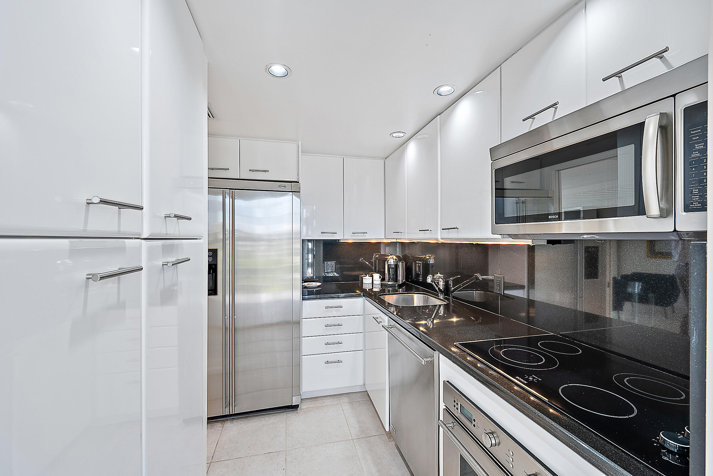 2780 South Ocean Boulevard, Unit 707 Palm Beach, FL 33480 - Photo 10 of 33 a kitchen with stainless steel appliances granite countertop a stove a refrigerator and a microwave