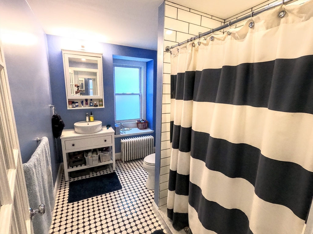 41 School Street, Unit 2 Boston, MA 02119 - Photo 12 of 36 a bathroom with a sink a toilet a shower and a mirror