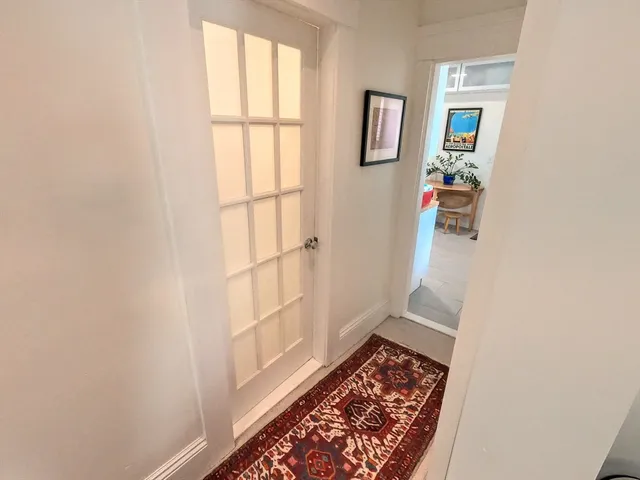 a view of hallway with window and a rug