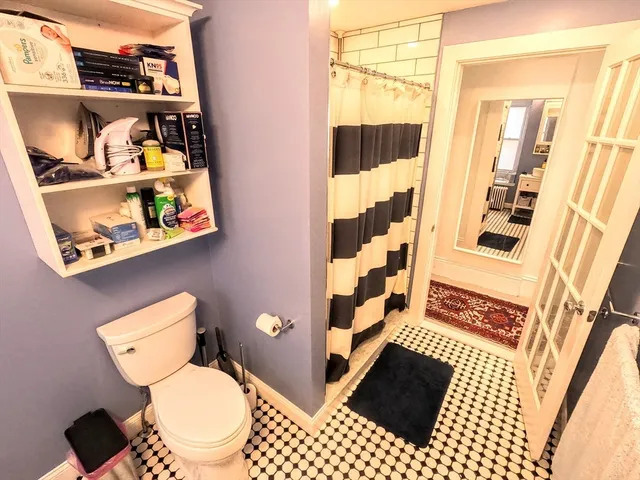 a bathroom with a toilet and a shower curtain