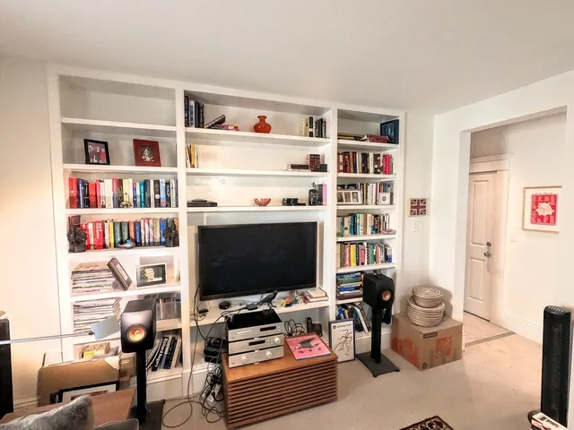 a living room with furniture and a book shelf