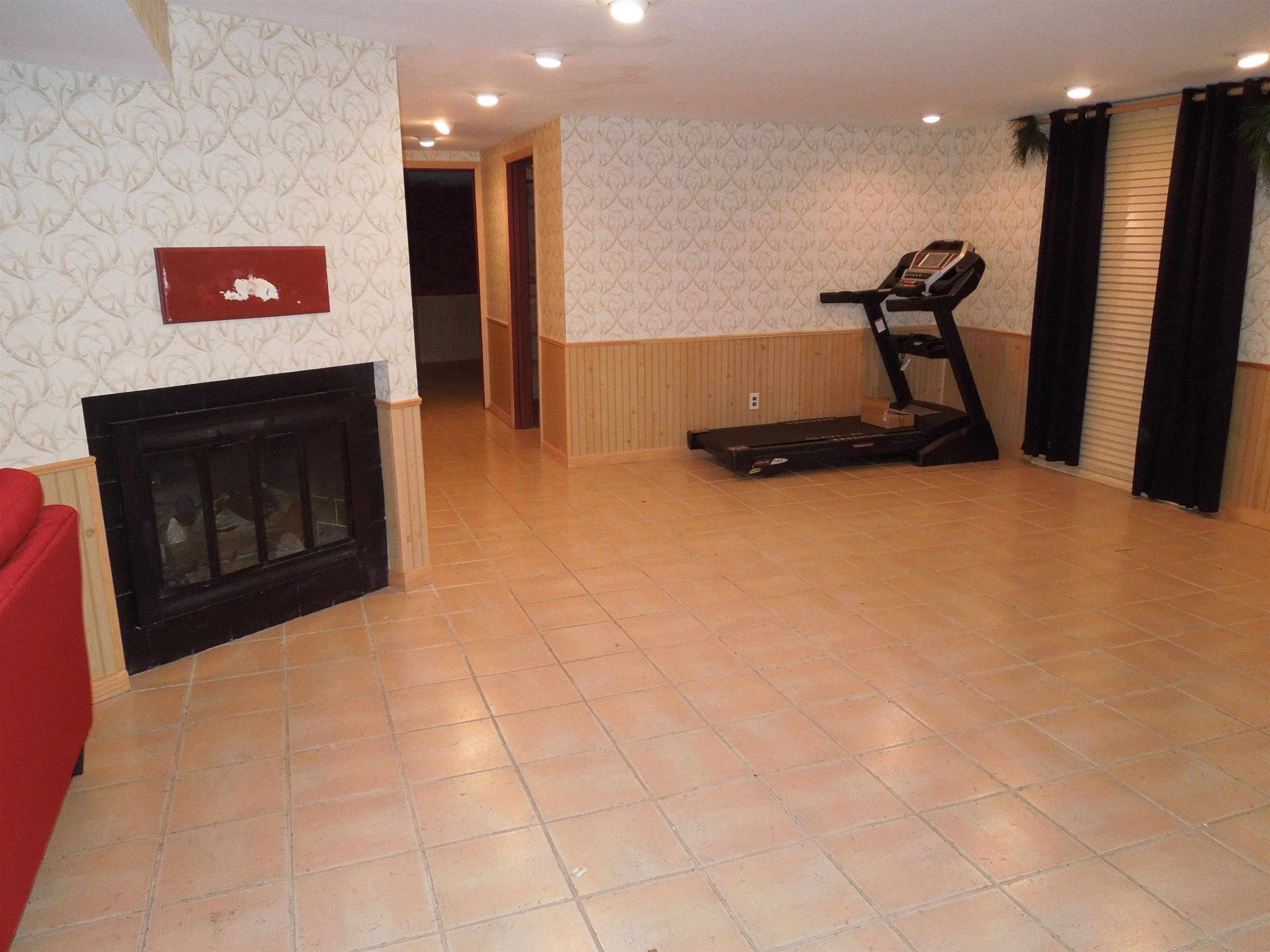 4721 Brookview Road Rockford, IL 61107 - Photo 19 of 26 a room with gym equipment and a flat screen tv