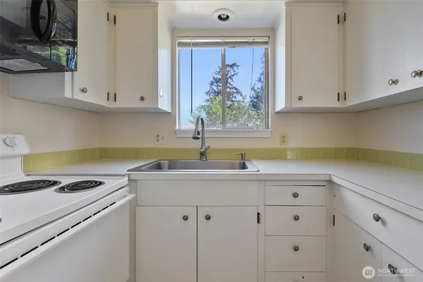 a kitchen with cabinets appliances and a window