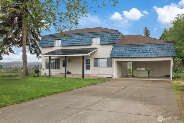 a front view of a house with a garden and yard