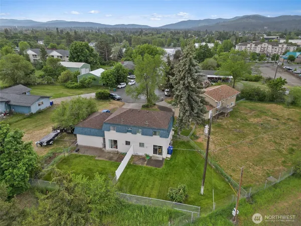 an aerial view of residential houses with outdoor space and trees