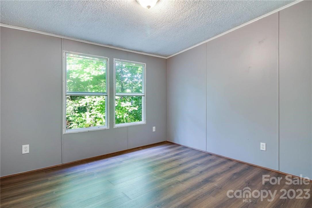 65 Hickory Nut Drive Mill Spring, NC 28756 - Photo 11 of 24 a view of an empty room with wooden floor and a window