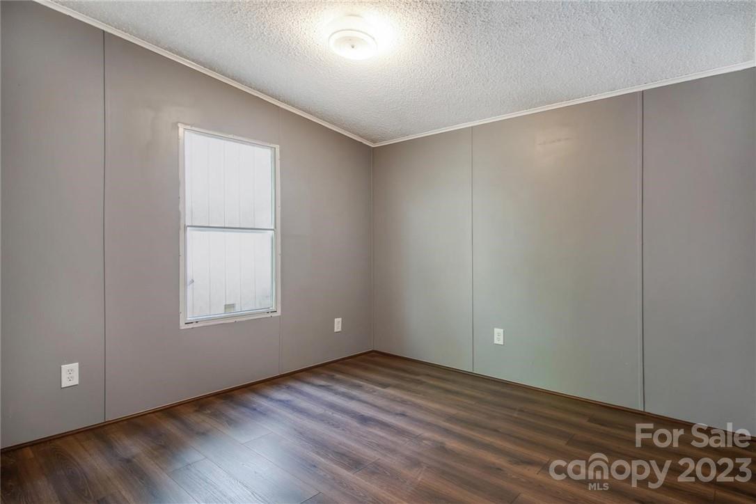 65 Hickory Nut Drive Mill Spring, NC 28756 - Photo 13 of 24 an empty room with wooden floor and windows