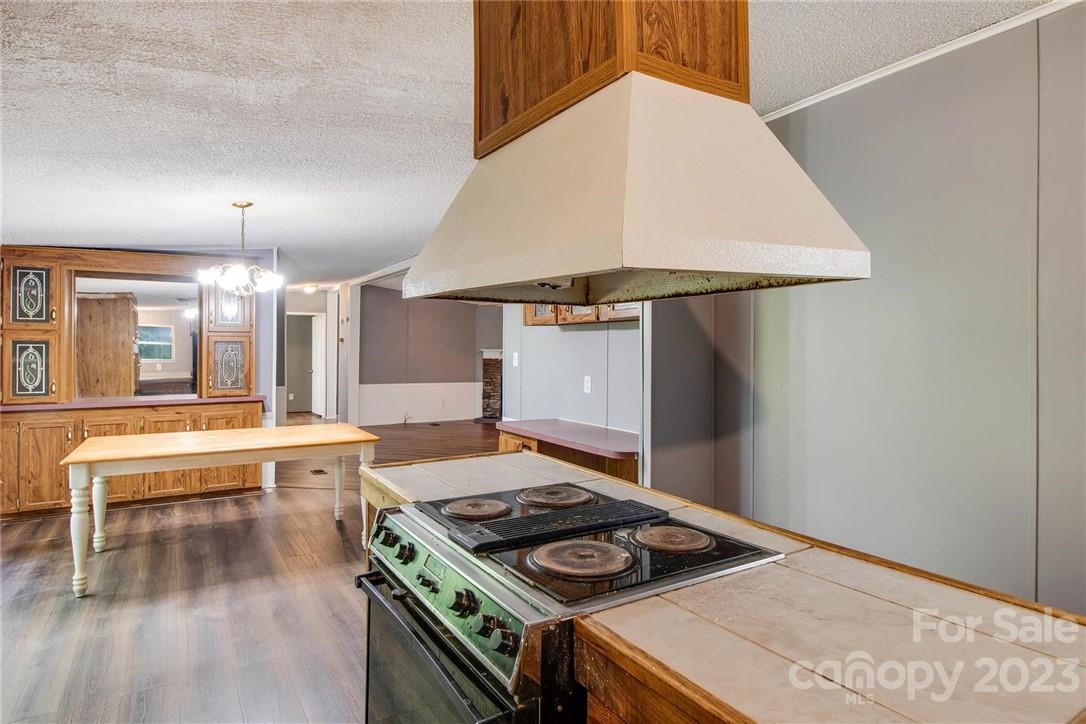 65 Hickory Nut Drive Mill Spring, NC 28756 - Photo 15 of 24 a kitchen with a stove and a wooden floor