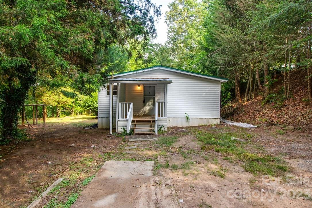 65 Hickory Nut Drive Mill Spring, NC 28756 - Photo 22 of 24 a backyard of a house with table and chairs