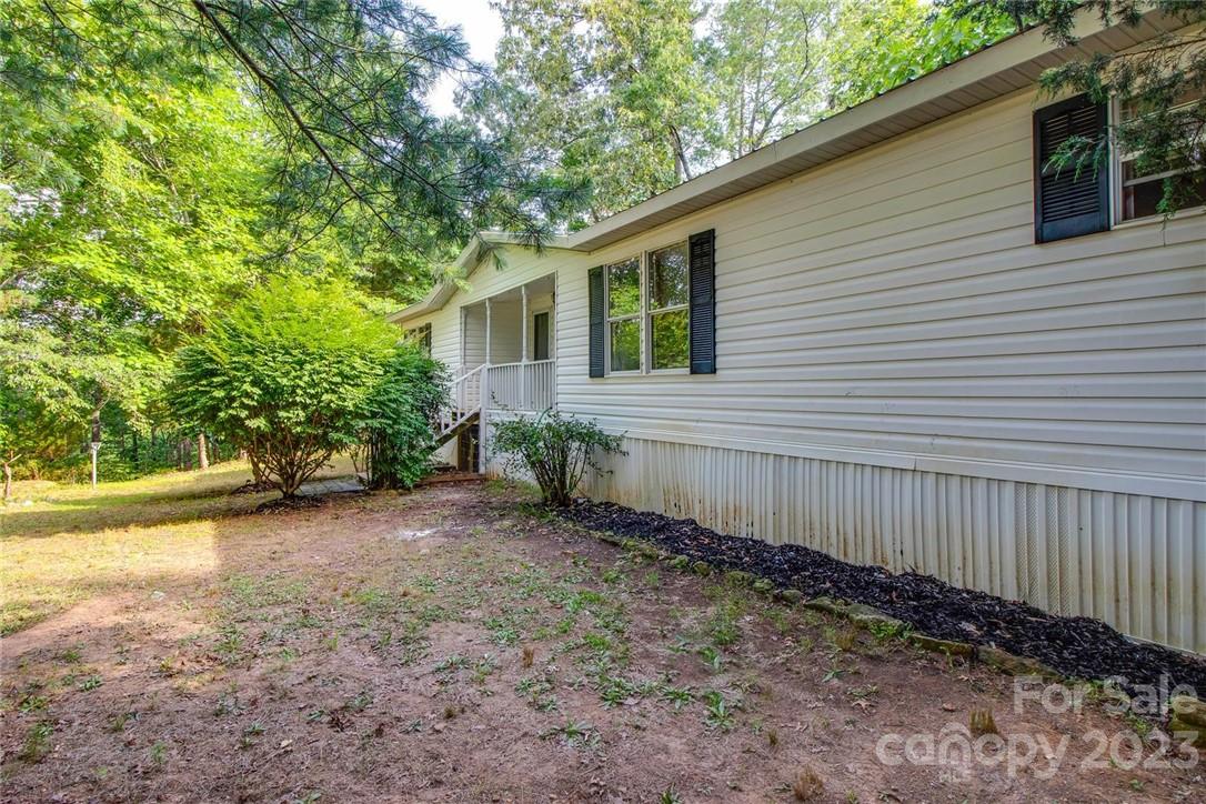 65 Hickory Nut Drive Mill Spring, NC 28756 - Photo 23 of 24 a view of a backyard with plants and large tree