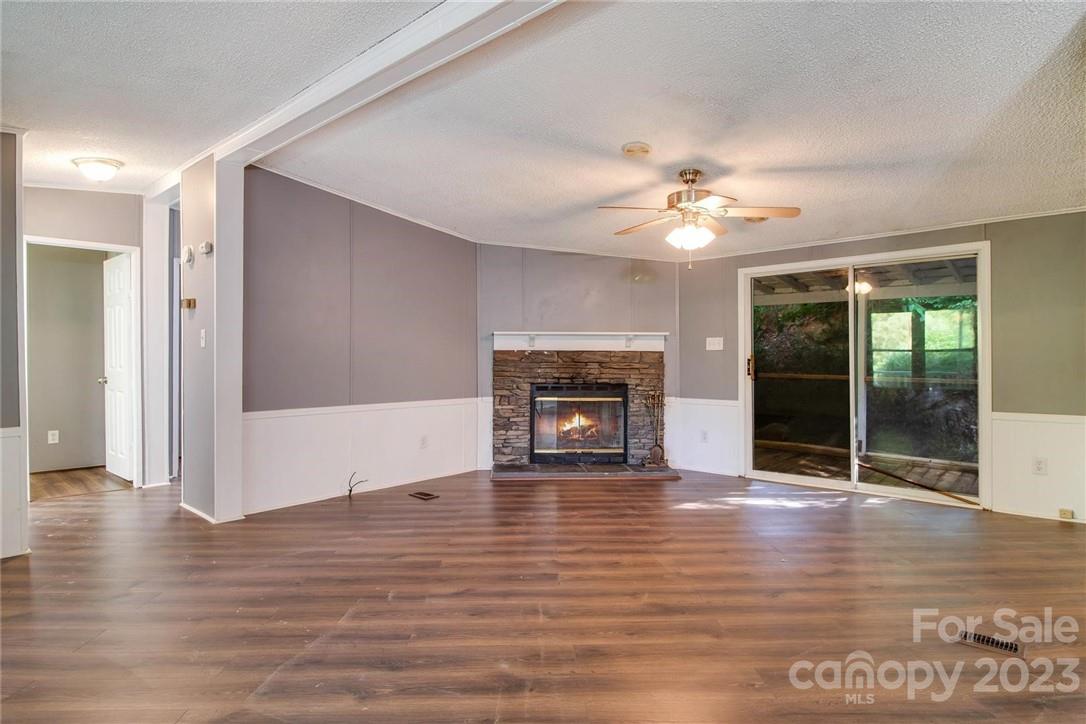 65 Hickory Nut Drive Mill Spring, NC 28756 - Photo 3 of 24 a view of an empty room with wooden floor and a fireplace