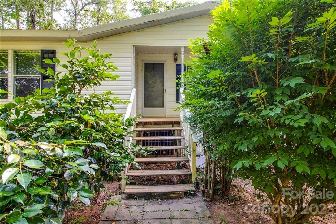 65 Hickory Nut Drive Mill Spring, NC 28756 - Photo 4 of 24 a view of a house with potted plants and a tree