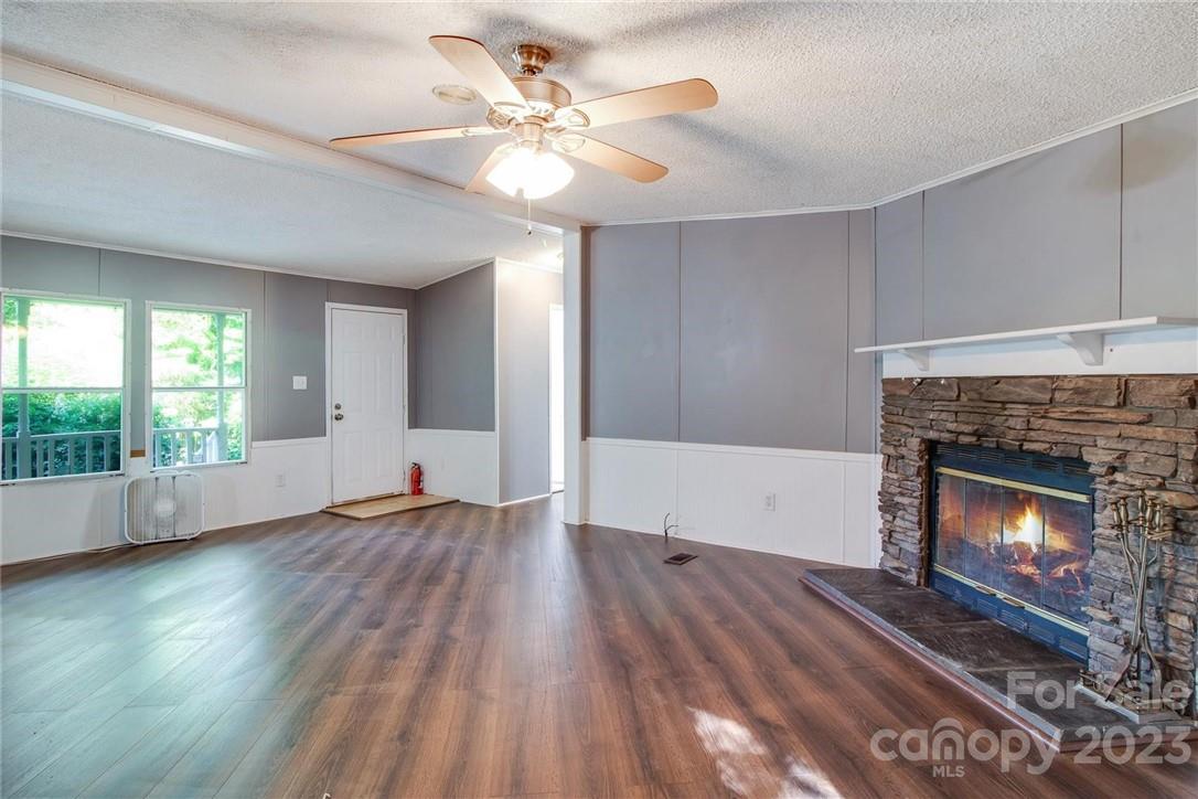 65 Hickory Nut Drive Mill Spring, NC 28756 - Photo 6 of 24 a view of an empty room with wooden floor fireplace and a window