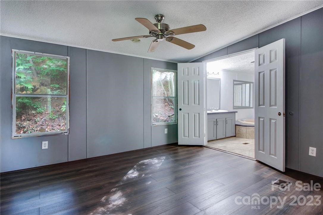 65 Hickory Nut Drive Mill Spring, NC 28756 - Photo 9 of 24 a view of an empty room with a window and wooden floor