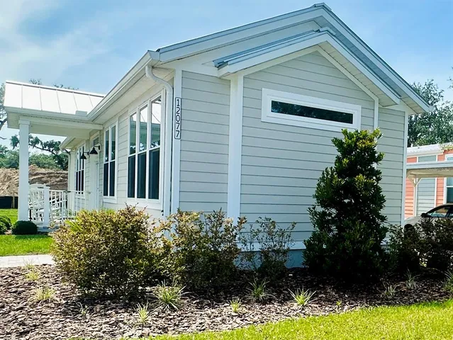 a view of a house with a yard and potted plants