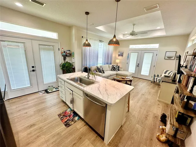 a open kitchen with a sink stove and wooden floor