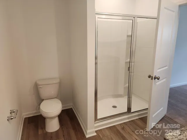 a bathroom with a toilet and a shower