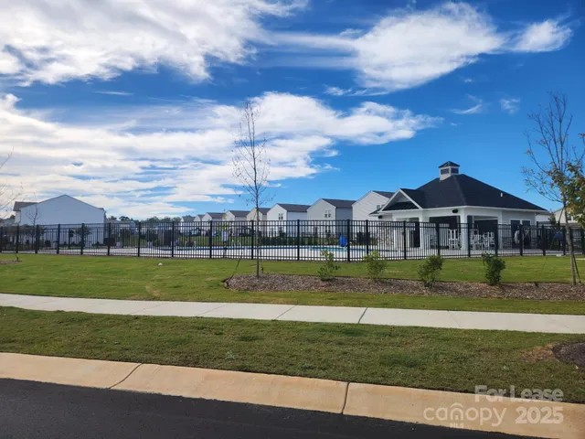 a view of a big house with a big yard and potted plants