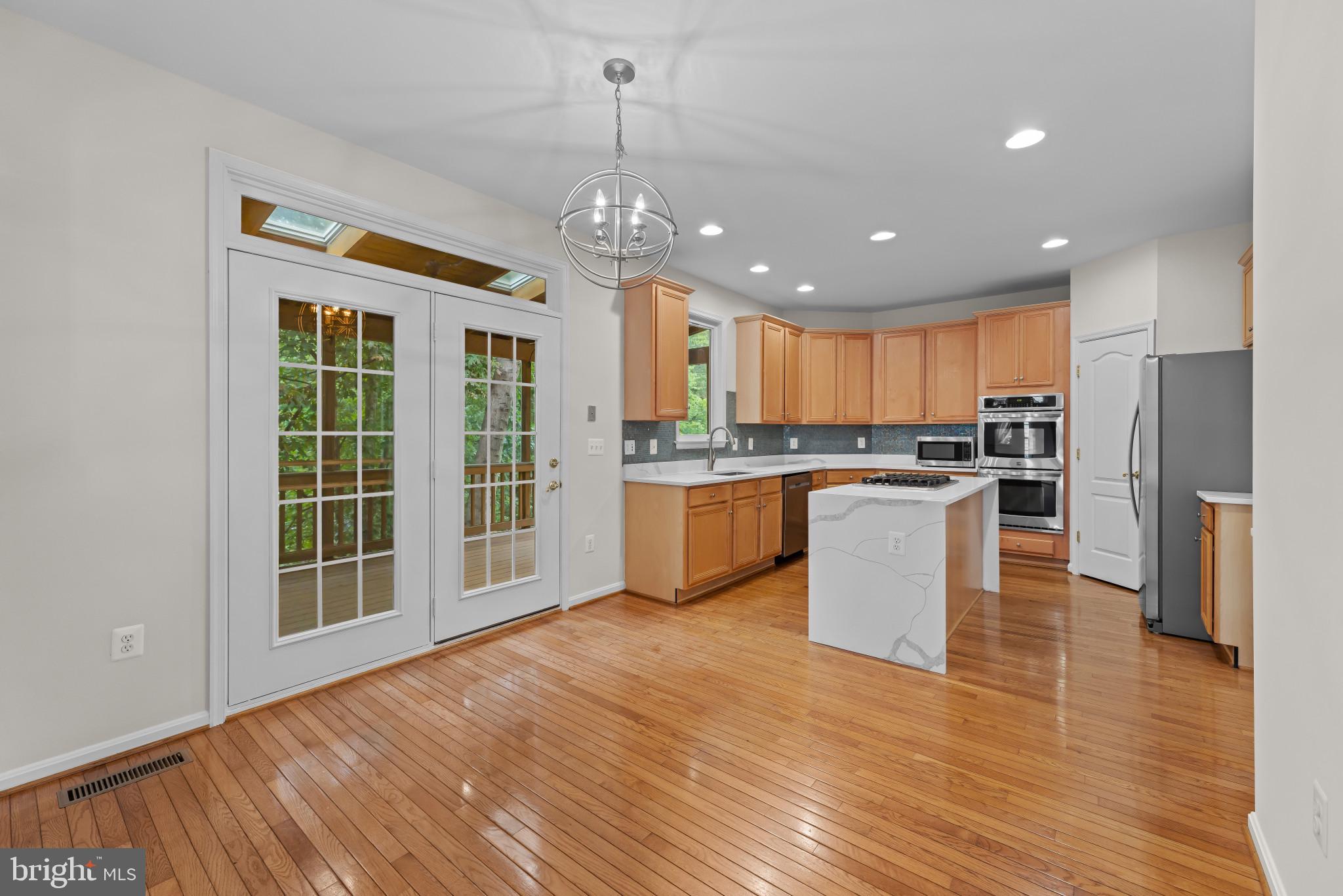 42920 Cattail Meadows Place Broadlands, VA 20148 - Photo 13 of 55 a large kitchen with kitchen island a island in the center and a large window