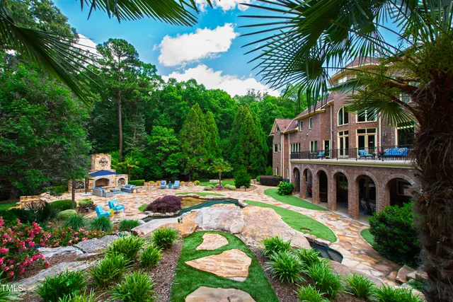 a view of a swimming pool with lawn chairs and a fire pit
