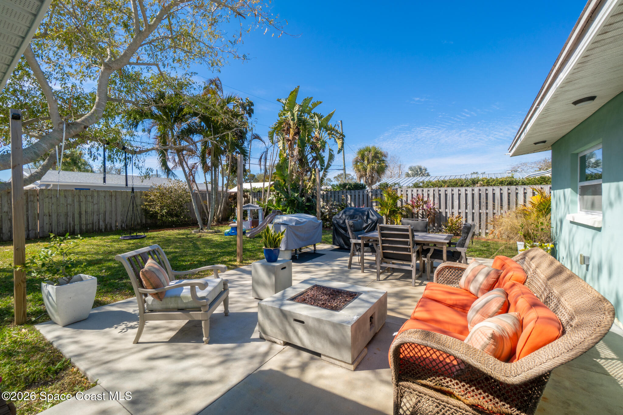 740 Java Road Cocoa Beach, FL 32931 - Photo 14 of 40 a view of a patio with couches chairs and a fire pit and wooden fence