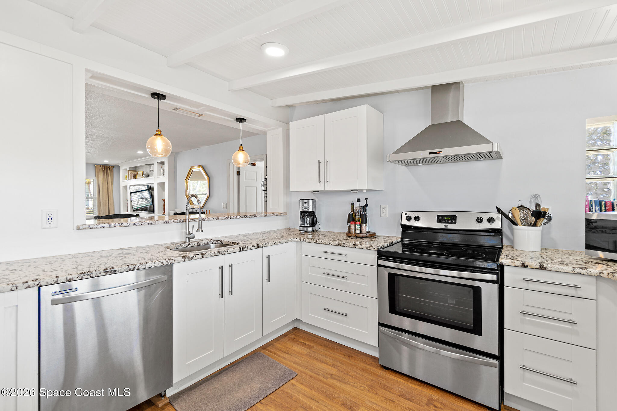 740 Java Road Cocoa Beach, FL 32931 - Photo 3 of 40 a kitchen with granite countertop white cabinets and white appliances