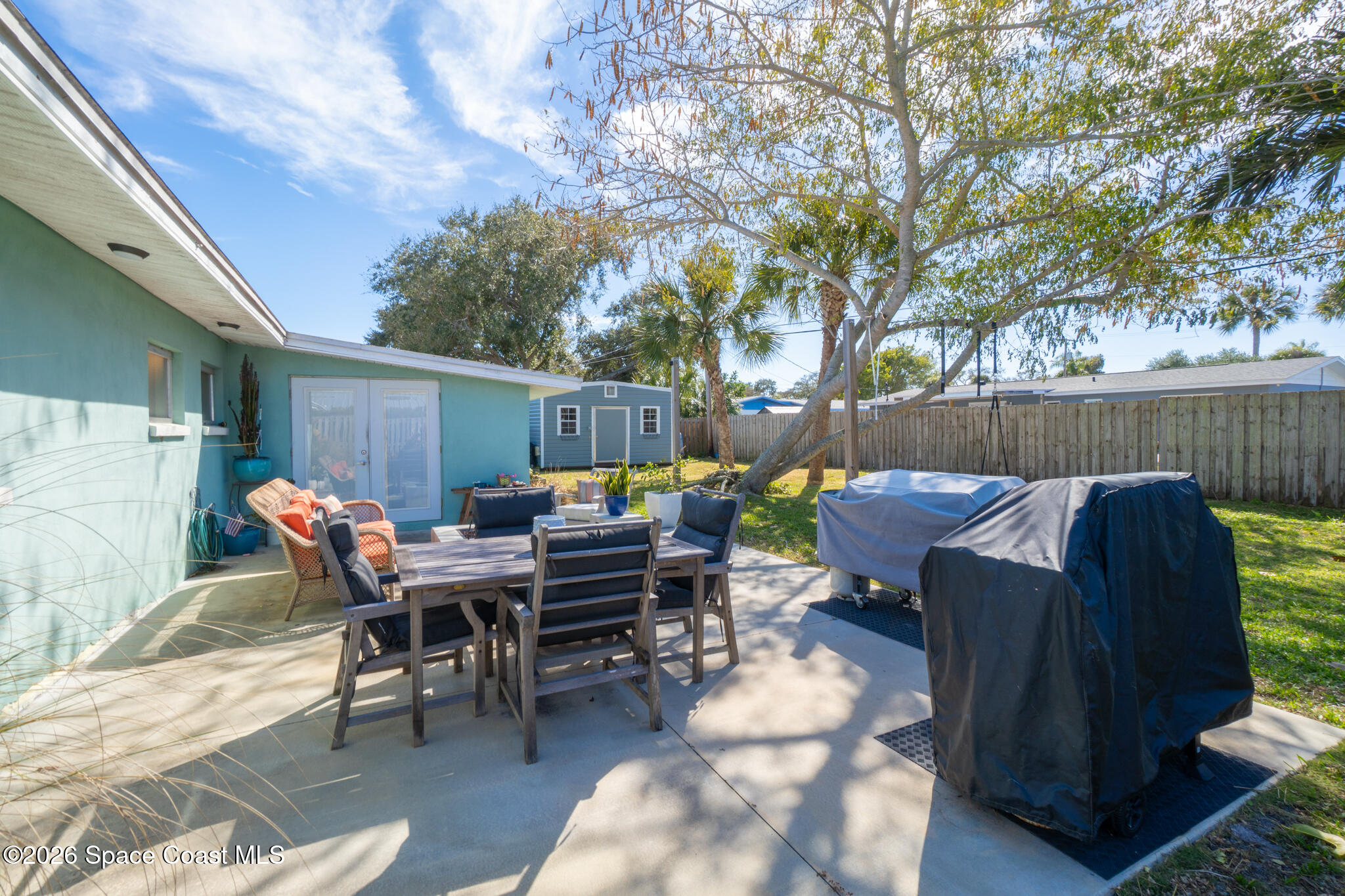 740 Java Road Cocoa Beach, FL 32931 - Photo 31 of 40 a view of a patio with table and chairs with wooden floor and fence