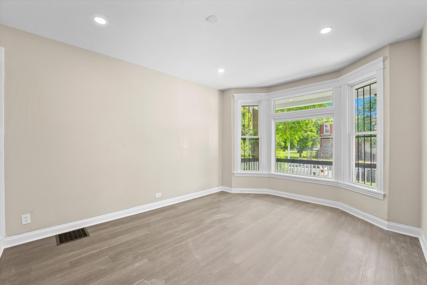 7224 South Union Avenue Chicago, IL 60621 - Photo 8 of 43 an empty room with wooden floor and windows