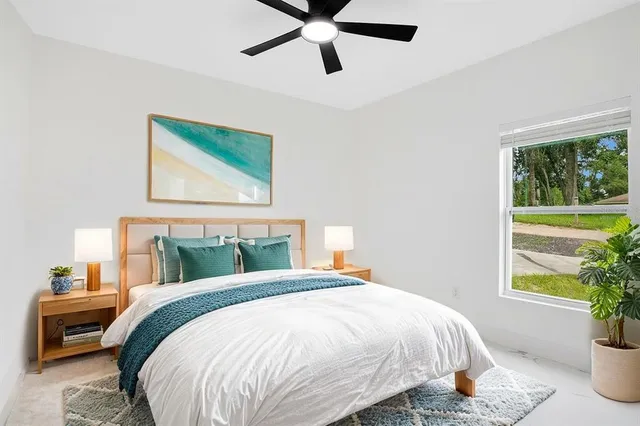 an empty room with a window and a ceiling fan