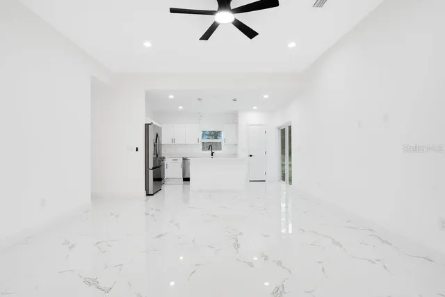 an empty room with windows and fan