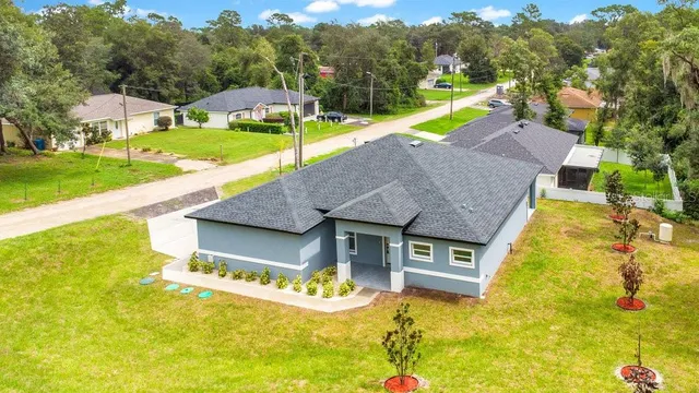 a aerial view of a house with swimming pool and large trees