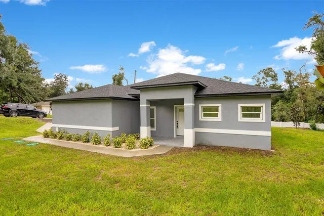 a house view with swimming pool in front of it