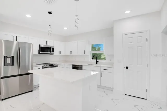 a kitchen with stainless steel appliances a refrigerator sink and stove