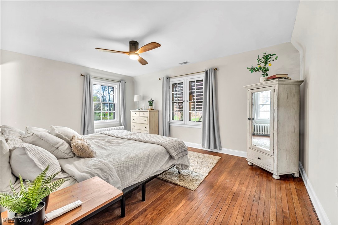 17409 Fernway Road Cleveland, OH 44120 - Photo 26 of 47 Bedroom featuring dark hardwood / wood-style flooring, multiple windows, ceiling fan, and radiator