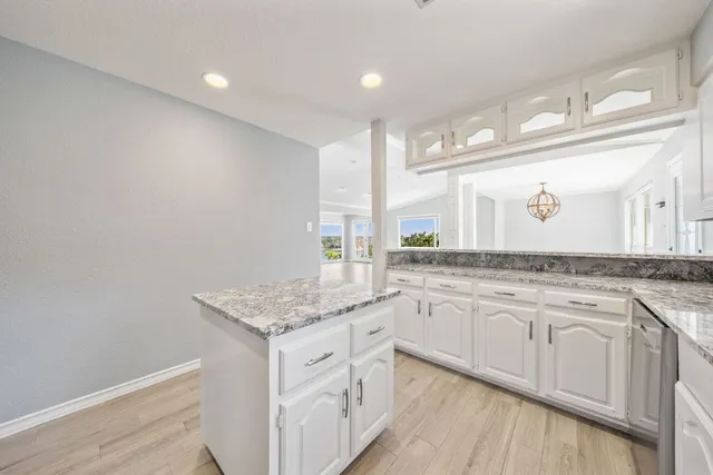 a bathroom with a granite countertop sink a large mirror and a window