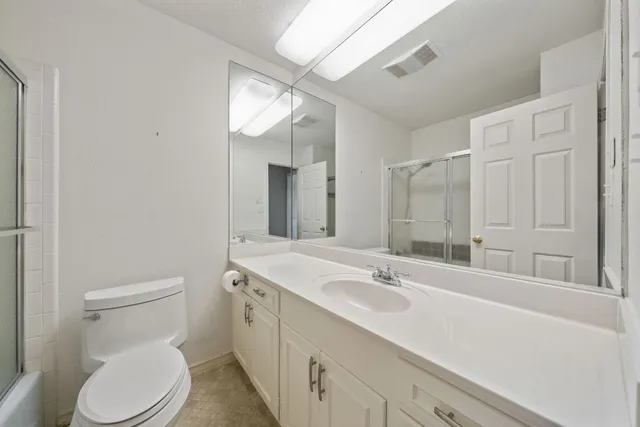 a bathroom with a sink a toilet and a large mirror