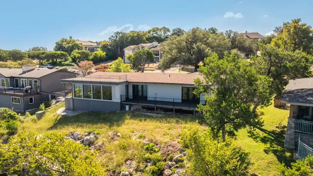 an aerial view of ocean and residential houses with outdoor space
