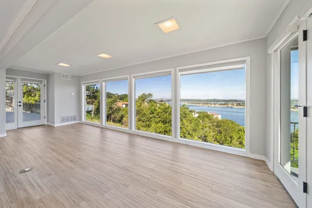 an empty room with wooden floor and windows