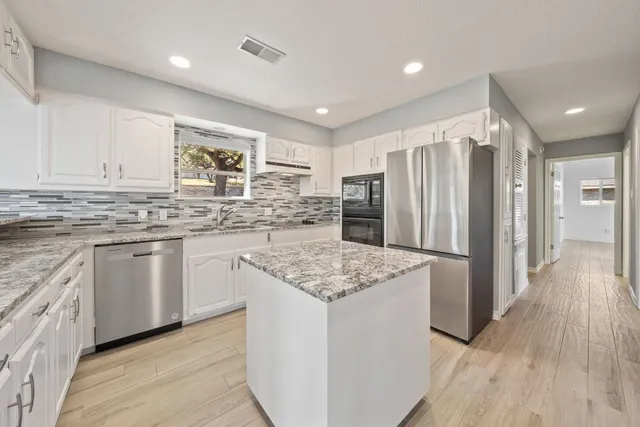 a kitchen with stainless steel appliances granite countertop a refrigerator sink and cabinets
