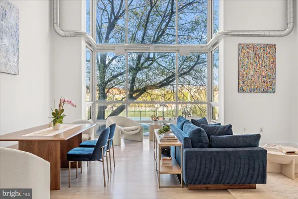 a living room with furniture and a floor to ceiling window