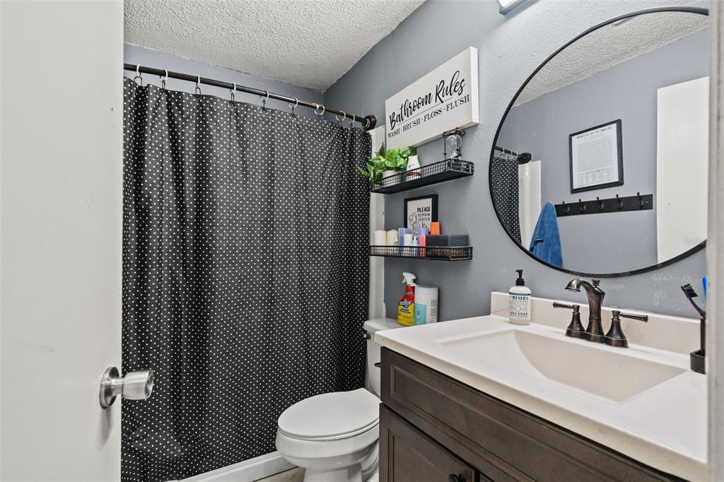 12989 Linden Drive Spring Hill, FL 34609 - Photo 16 of 28 a bathroom with a sink toilet mirror and shower