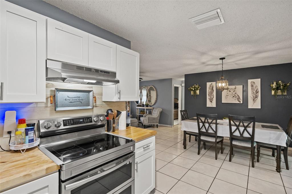 12989 Linden Drive Spring Hill, FL 34609 - Photo 7 of 28 a kitchen with a stove and white cabinets