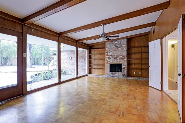 a view of an empty room with a fireplace and a window