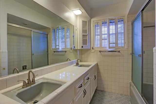 a bathroom with a sink double vanity and a shower